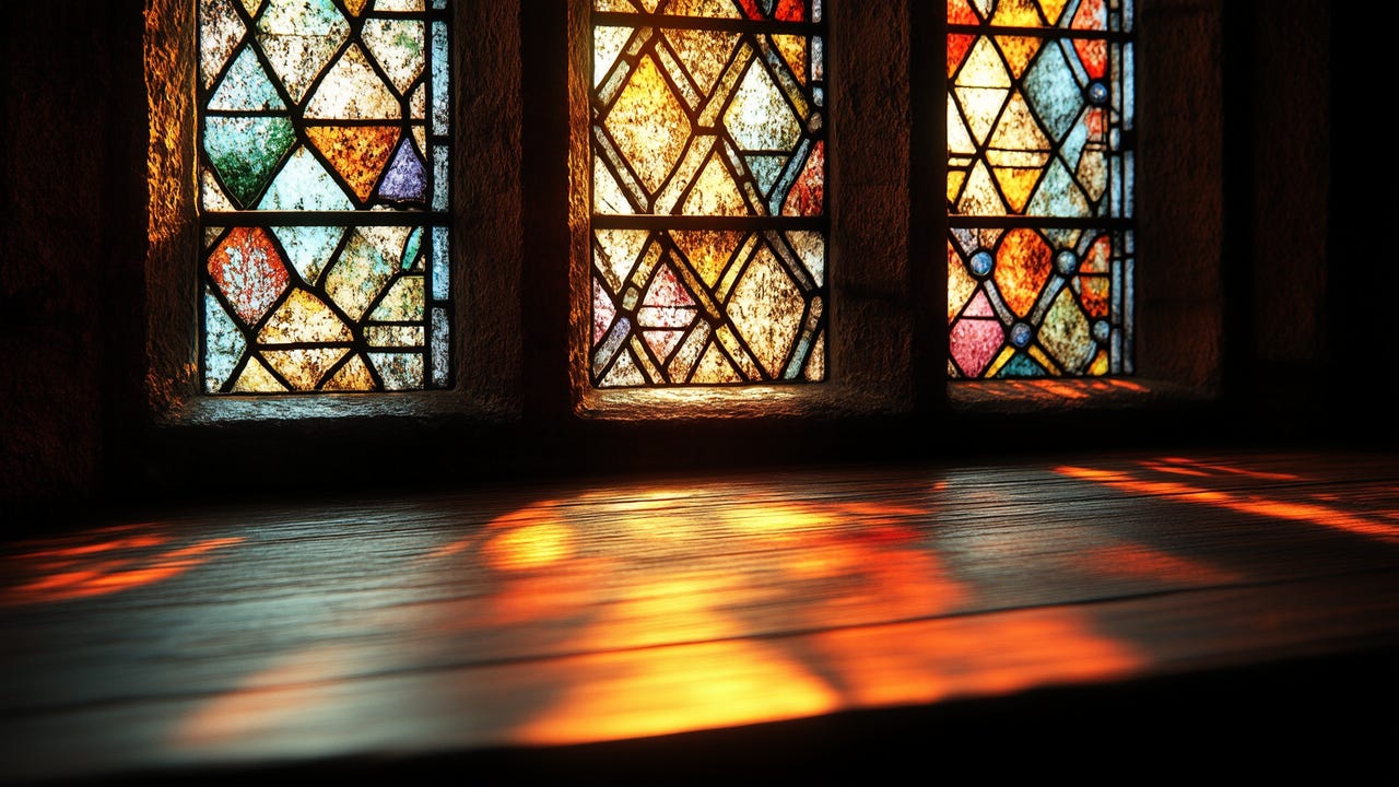 A close-up of a Tudor-style stained-glass window with intricate geometric patterns. The aged glass has warm hues of amber, red, and blue, with soft sunlight filtering through. The light casts a rich, golden glow onto a wooden surface below, creating an atmospheric and serene scene reminiscent of the Renaissance era. The textured stone frame and rustic wood add to the historical ambiance, evoking the spirit of 16th-century craftsmanship and artistry.