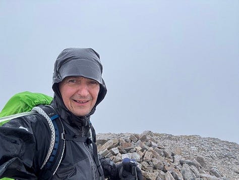 A local wood carving on the trail, a wet top, and a view of the Grey Corries
