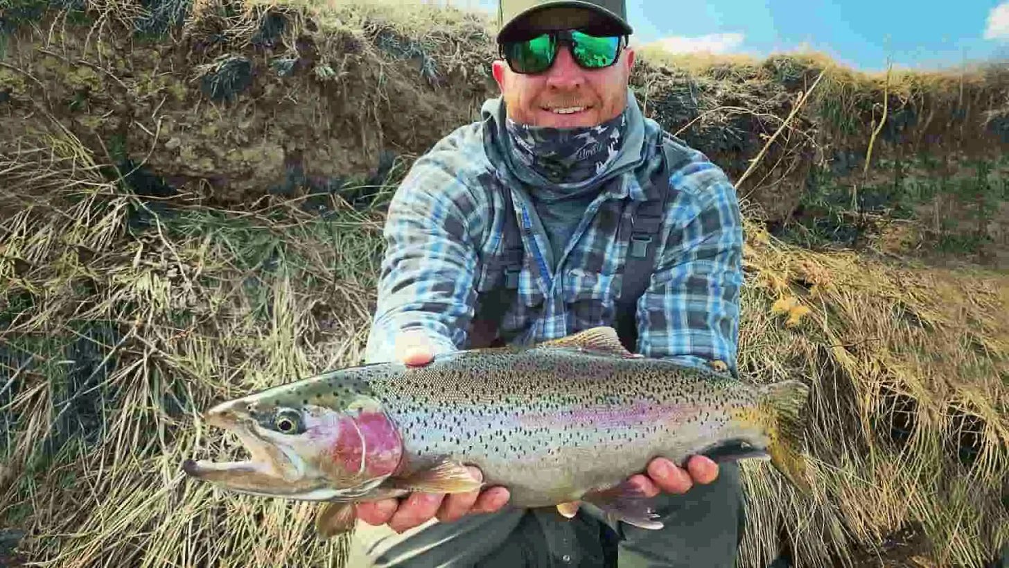 Angler in Flannel Shirt with Bright Rainbow Trout