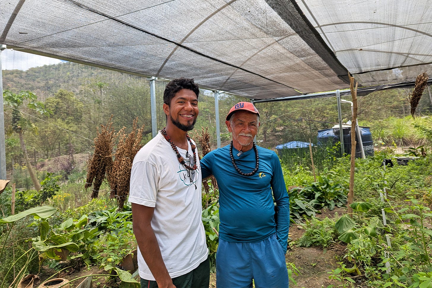 Hemerson Dantas dos Santos Pataxó HaHaHãi and Aniraldo Xavier Kariri-Sapuyá pose for a photo amid 150 plants inside "Horta Medicinal," a reference medicinal garden set up in 2023 in the village of Caramuru by the federal government. Image by Karla Mendes/Mongabay.