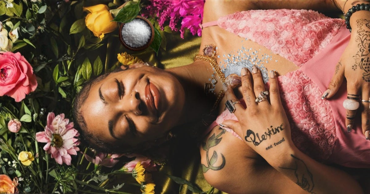 Lightly digitally collaged photo of a brown-skinned person holding salt to her heart like balm. 