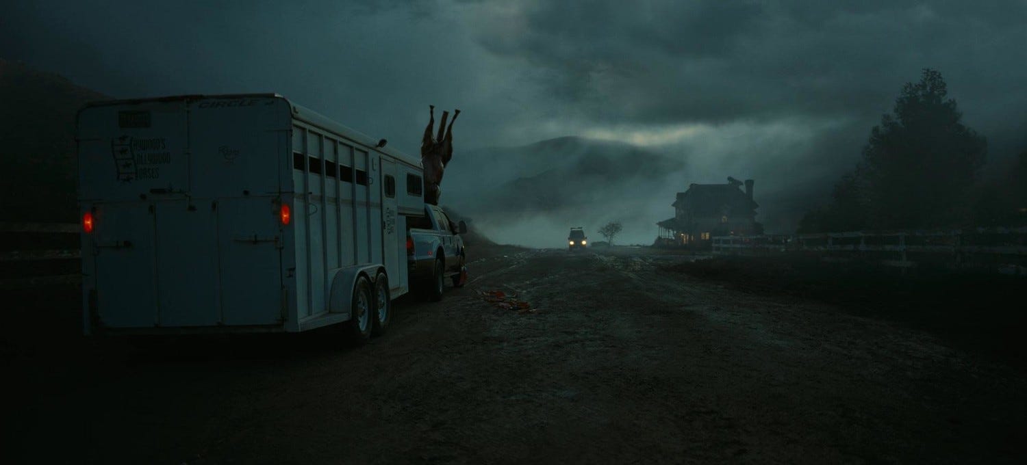 Screenshot from "Nope." A truck in the distance drives through a foggy, dark path.