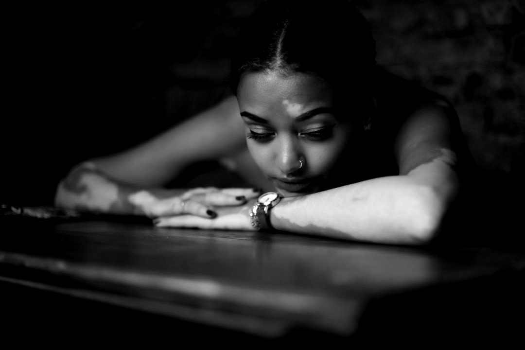 woman in red and white floral dress lying on brown wooden table