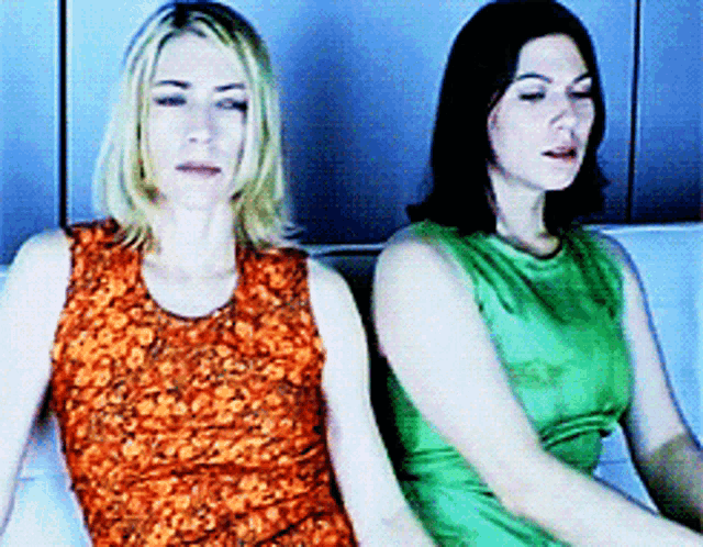 Gif animé de Kim Gordon et Kim Deal, assises sur un canapé, qui tournent la tête l'une vers l'autre.