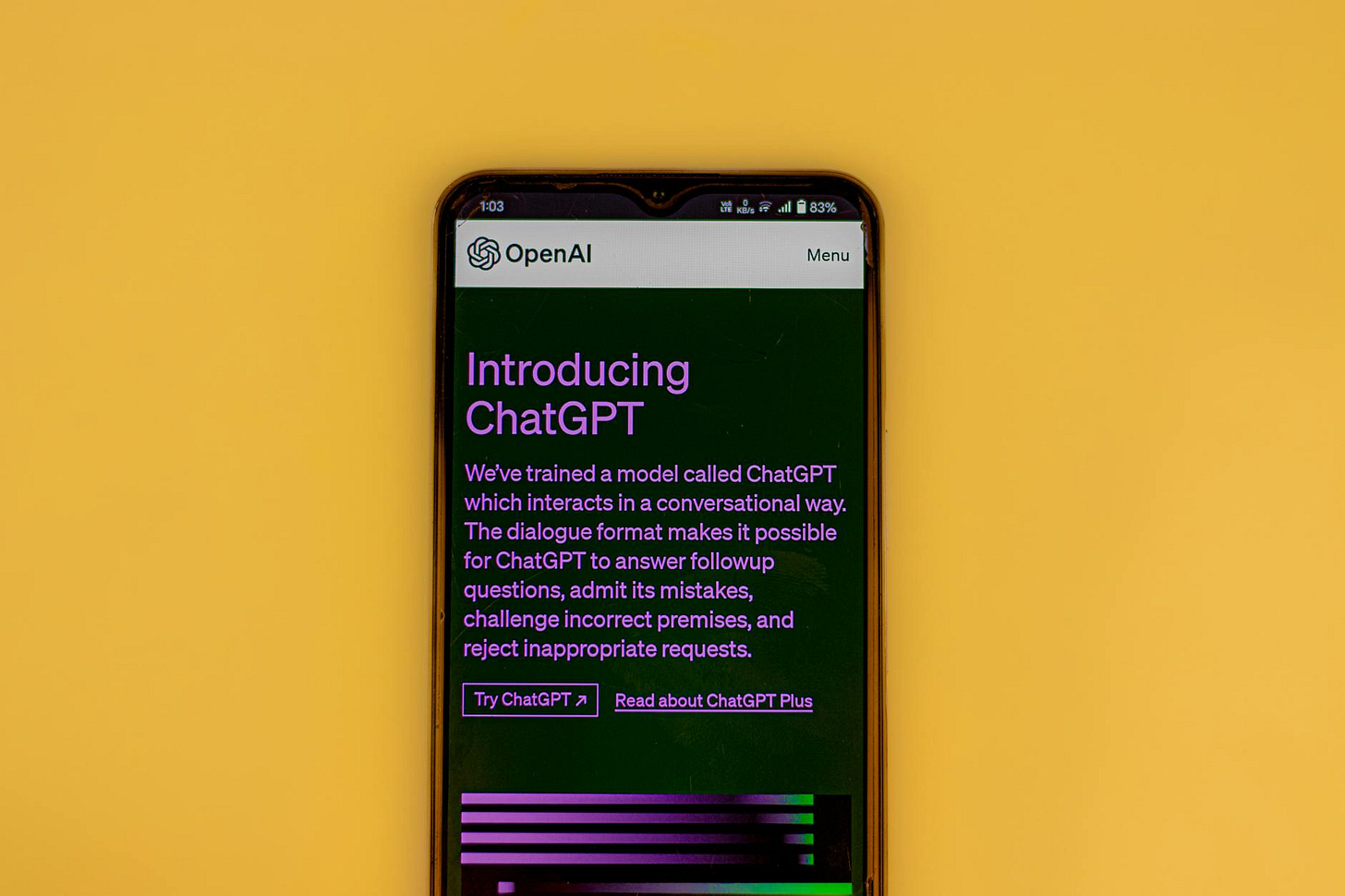 Mobile phone displaying the ChatGPT introduction screen with OpenAI branding on a yellow background.