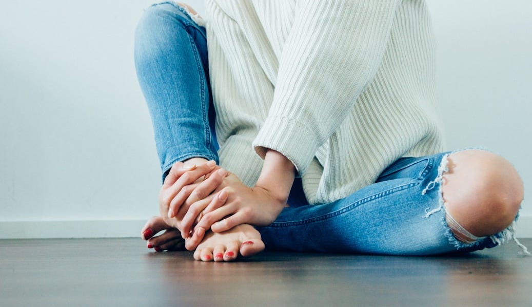 person wearing distressed blue denim jeans inside room person wearing distressed blue denim jeans inside room