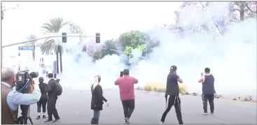 A group of people walking on a street with smoke

AI-generated content may be incorrect.