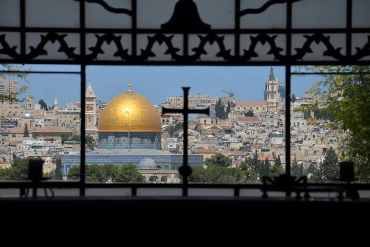 A view of the Dome of the Rock, from a window with cross ironwork, in Jerusalem.