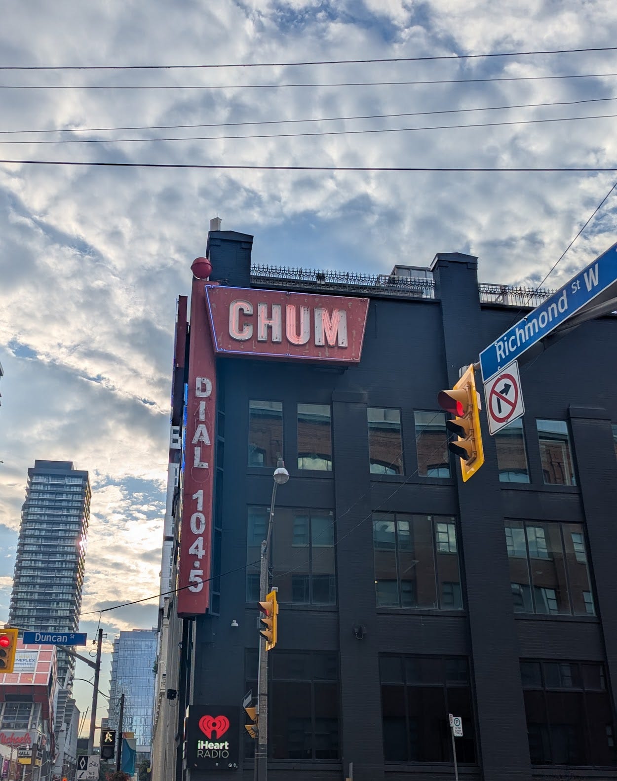 Dark multi-story building with blade signs reading CHUM and DIAL 1045