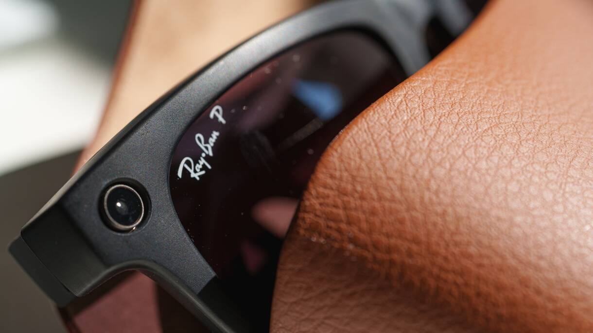Close-up of black Ray-Ban Meta Smart Glasses with a visible camera protruding from the case.