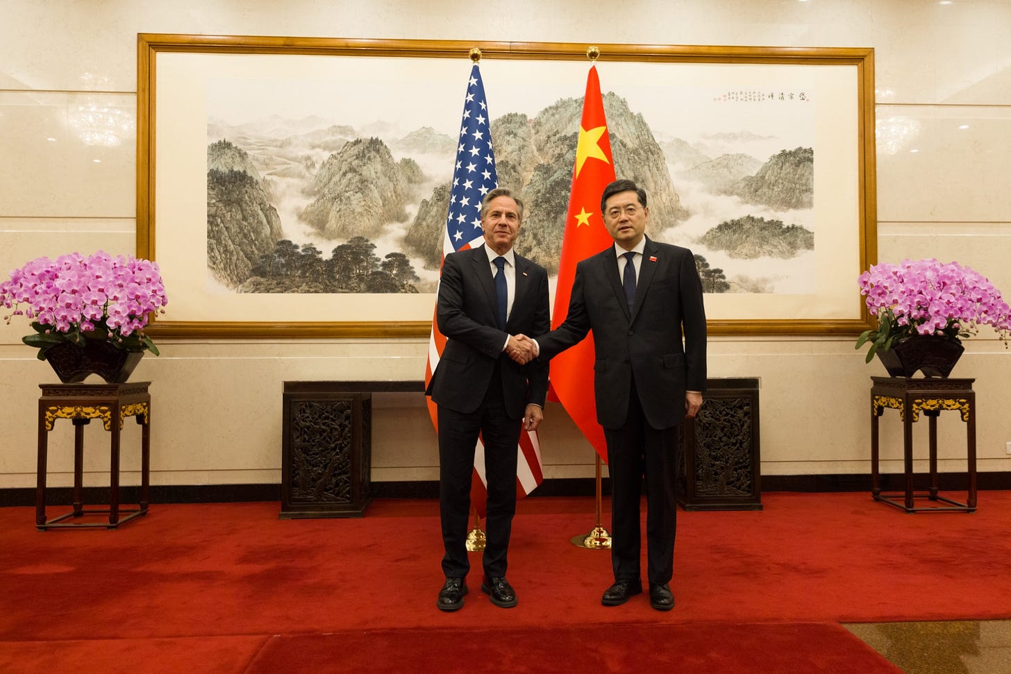 Secretary Blinken shakes hands with People’s Republic of China State Councilor and Foreign Minister Qin Gang in Beijing. U.S. and PRC flags are behind them. 