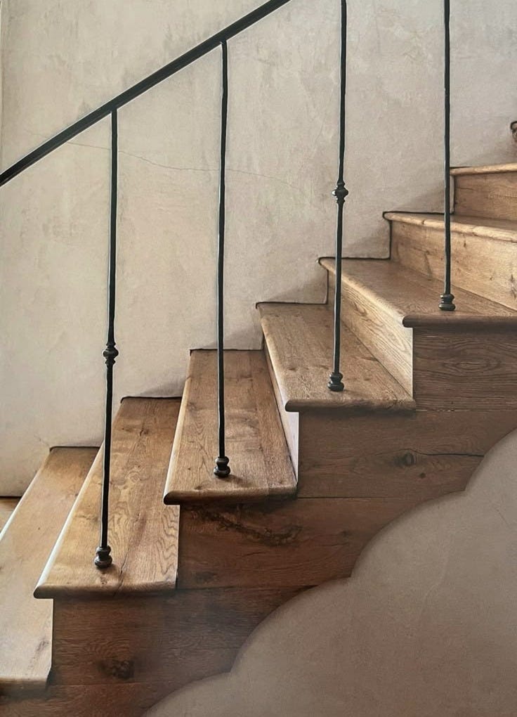 This may contain: a set of wooden stairs with metal handrails