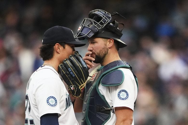 Seattle Mariners starting pitcher Bryan Woo, left, talks with catcher Cal Raleigh, right, on the mound during the first inning of a baseball game against the Texas Rangers, Saturday, April 12, 2025, in Seattle. (AP Photo/Lindsey Wasson) (Lindsey Wasson / AP)