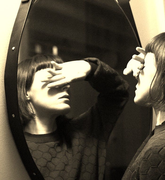 woman in black long sleeve shirt standing in front of mirror