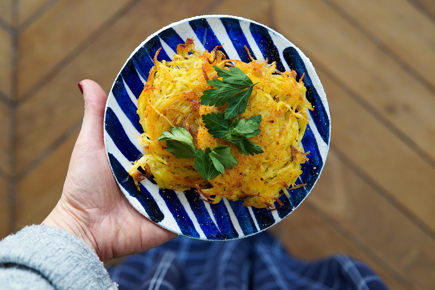 les latkes cuits dans une assiette que je tiens dans ma main