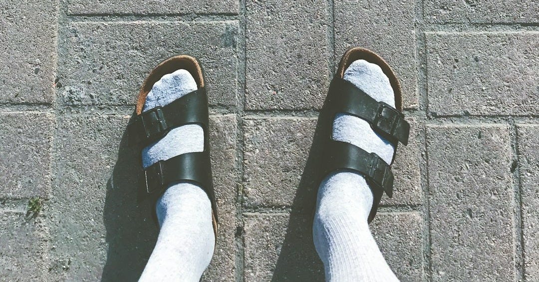 person wearing black and white slide sandals
