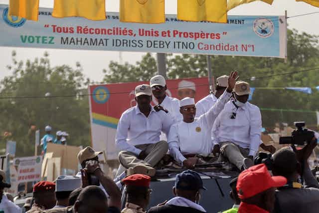 Man wearing white kaftan dress and cap surrounded by other men wearing white shirts. Man wearing white kaftan dress and cap surrounded by other men wearing white shirts.