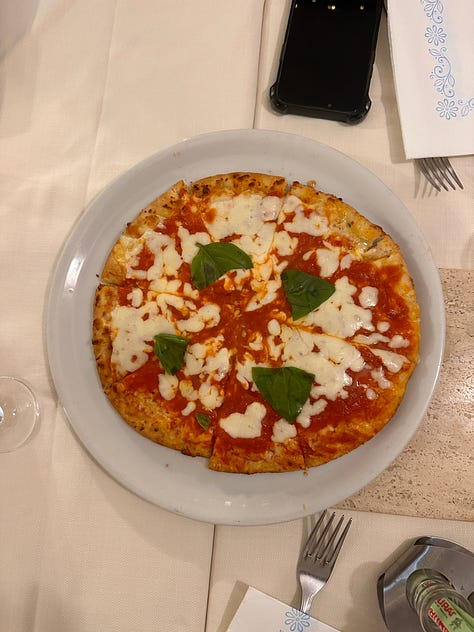sharing some cold cuts, magherita pizza, an empty cup of tiramisu, pasta and a group shot on the rooftop