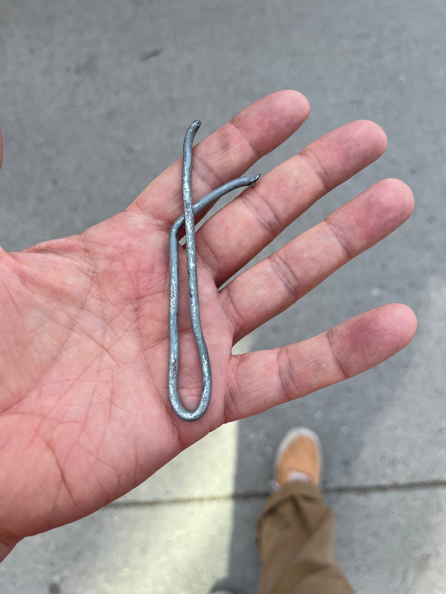 A twisted piece of thick-guage wire with a couple of nasty pointy ends just waiting to dig into the tire of an unsuspecting vehicle A twisted piece of thick-guage wire with a couple of nasty pointy ends just waiting to dig into the tire of an unsuspecting vehicle