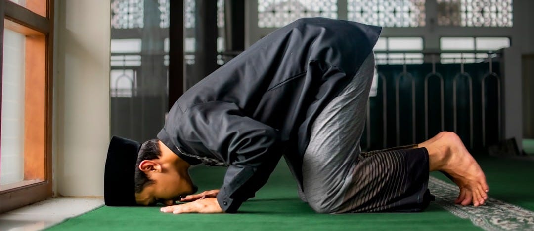 a man in a suit is doing a handstand on the floor