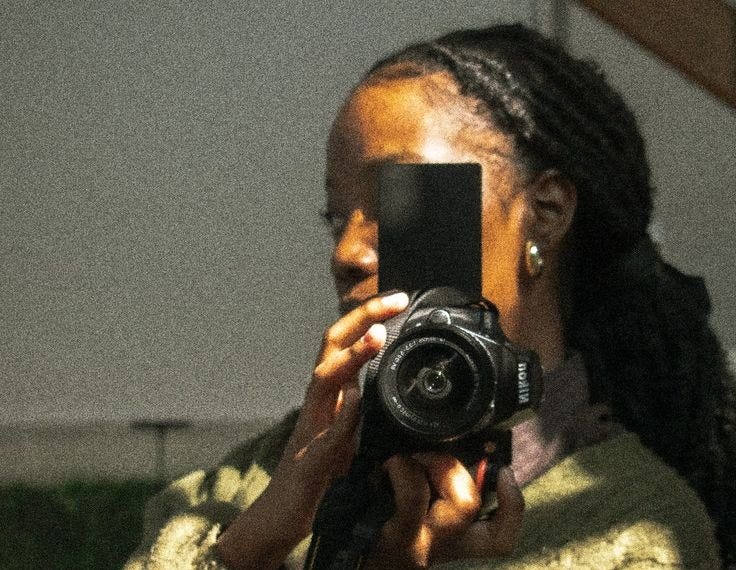 This may contain: a woman holding a camera up to her face This may contain: a woman holding a camera up to her face