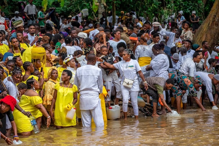 A group of people by a river A group of people by a river
