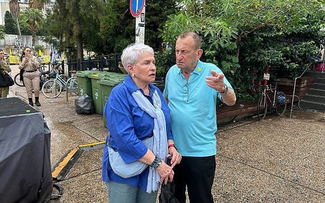 Tel Aviv mayor Ron Huldai, right, talks with a woman near Hostages Square in Tel Aviv on October 9, 2025. (Ben Sales/Times of Israel)