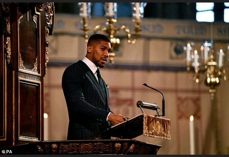 This may contain: a man standing at a podium in front of a microphone