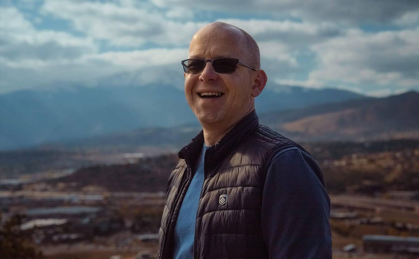 A person wearing sunglasses and a vest

Description automatically generated