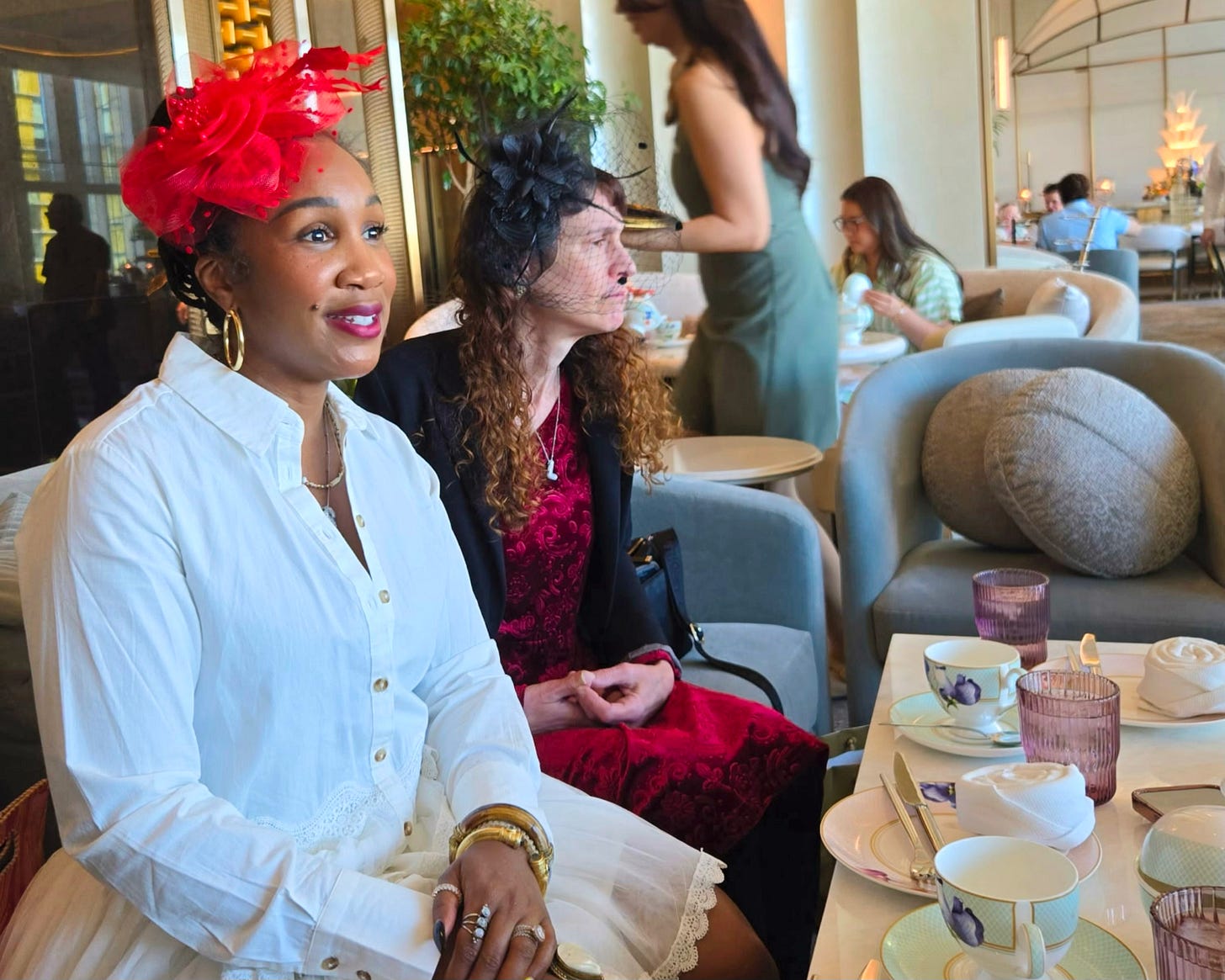 Women founders gathered for high tea in Las Vegas wearing elegant fascinator hats, sharing conversation and community while celebrating creativity, leadership, and the power of women supporting women in business.