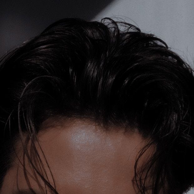 This may contain: the back of a woman's head with dark hair and an undercut on it