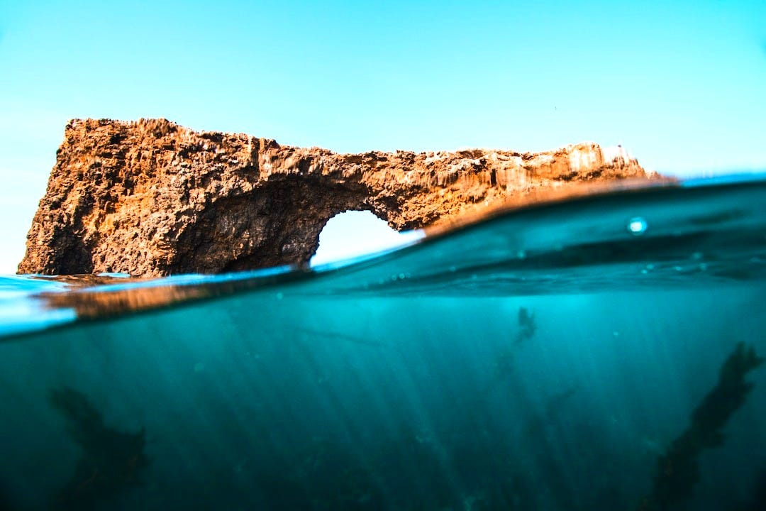 brown rock over body of water