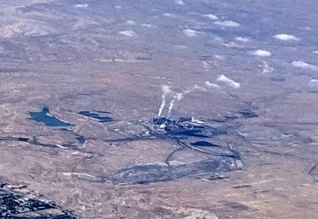 A coal plant in a high desert landscape, with two plumes of exhaust rising from it