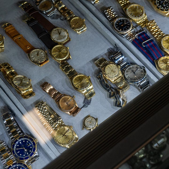 Pile of vintage gold Rolex and Cartier watches