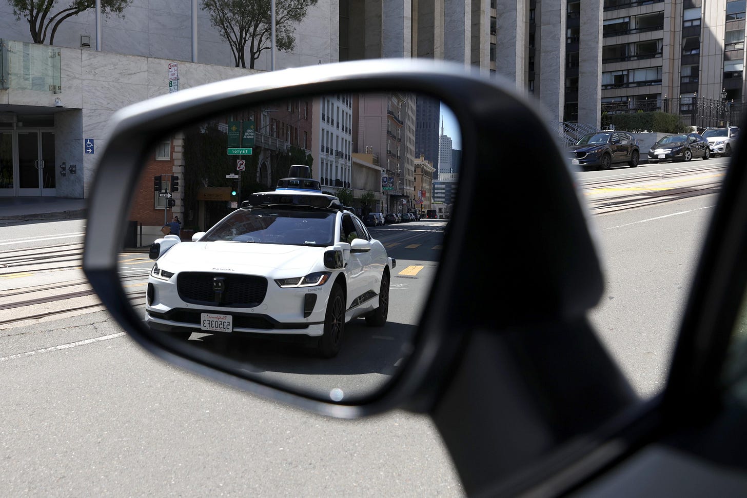SAN FRANCISCO, CALIFORNIA - APRIL 11: A Waymo autonomous vehicle is seen reflected in a mirror as it drives along California Street on April 11, 2022 in San Francisco, California. San Francisco is serving as testing grounds for autonomous vehicles with Waymo, a Google subsidiary and Cruise, a subsidiary of General Motors, logging millions of test miles throughout San Francisco in 2021. (Photo by Justin Sullivan/Getty Images)