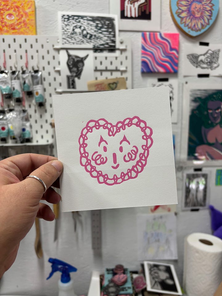 one valentine is a clown face in a heart and the other is two little demon guys smooching inside a heart
