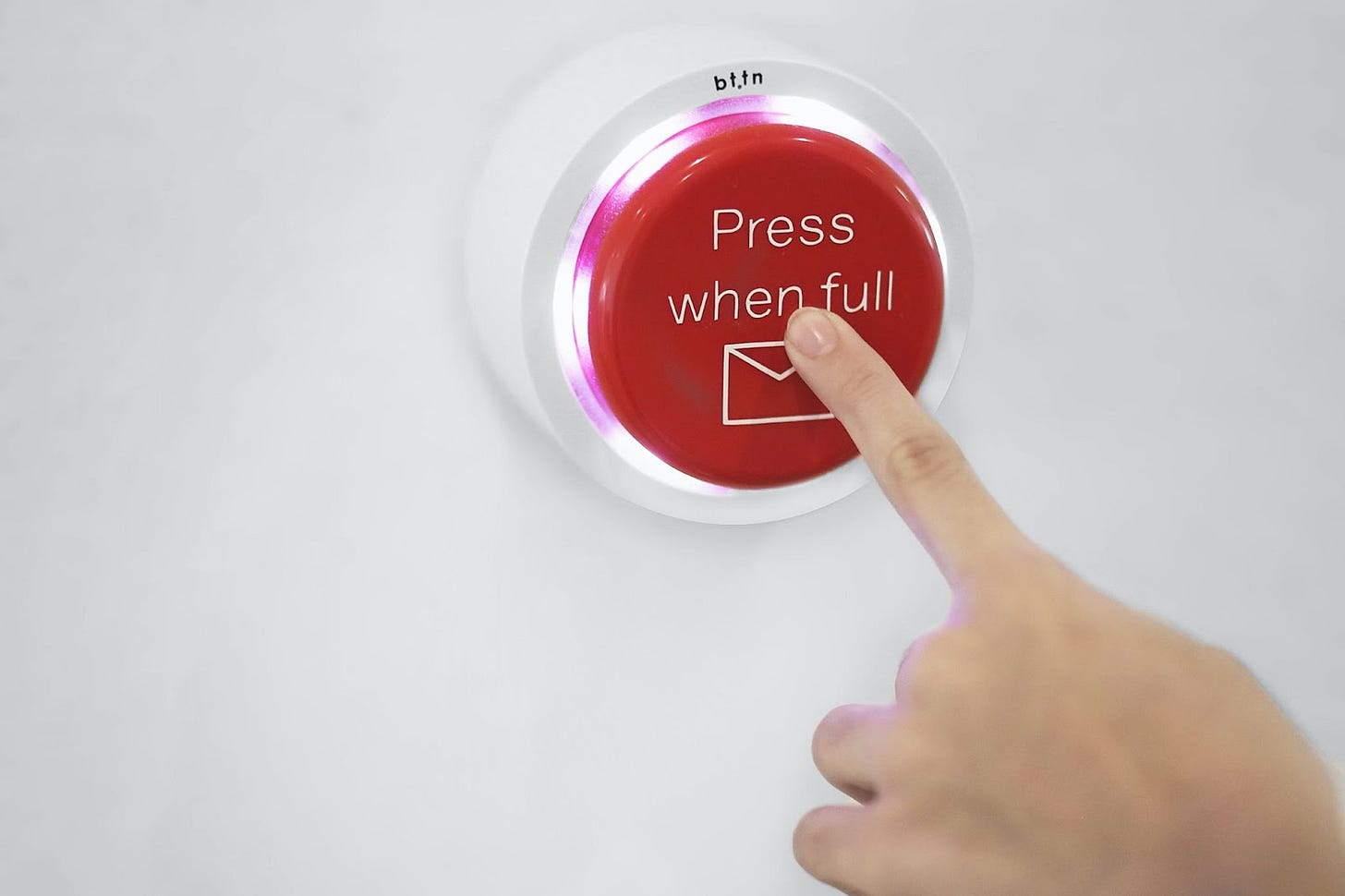 A person pushing a red button that says “Press when full” and includes an email icon. A person pushing a red button that says “Press when full” and includes an email icon.