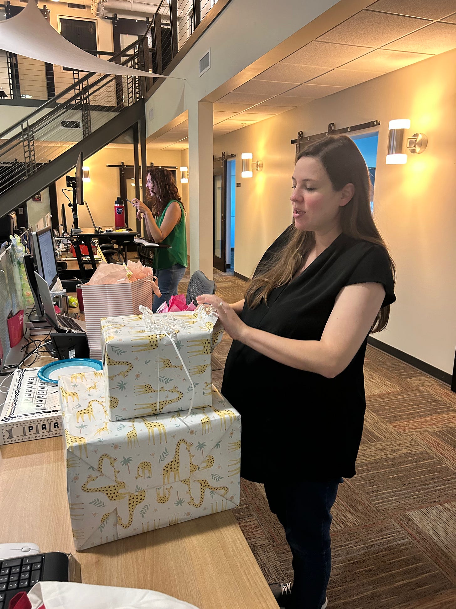A pregnant mom opens a baby gift. A pregnant mom opens a baby gift.