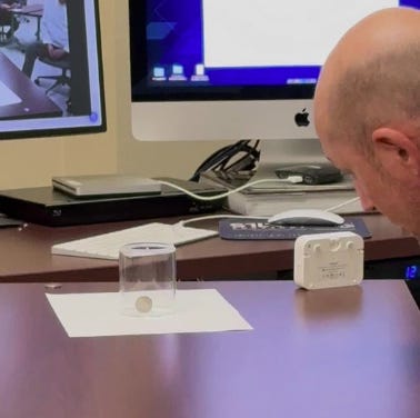 A person looking at a coin in a glass container

AI-generated content may be incorrect.