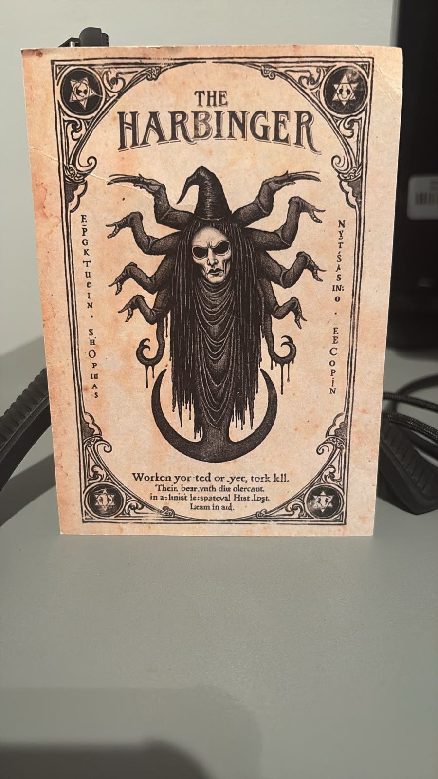 Illustrated Harbinger card featuring a sinister skeletal, jester-like figure with multiple arms, shared during the Tarot DMs interview about the supernatural horror film Harbinger. Illustrated Harbinger card featuring a sinister skeletal, jester-like figure with multiple arms, shared during the Tarot DMs interview about the supernatural horror film Harbinger.