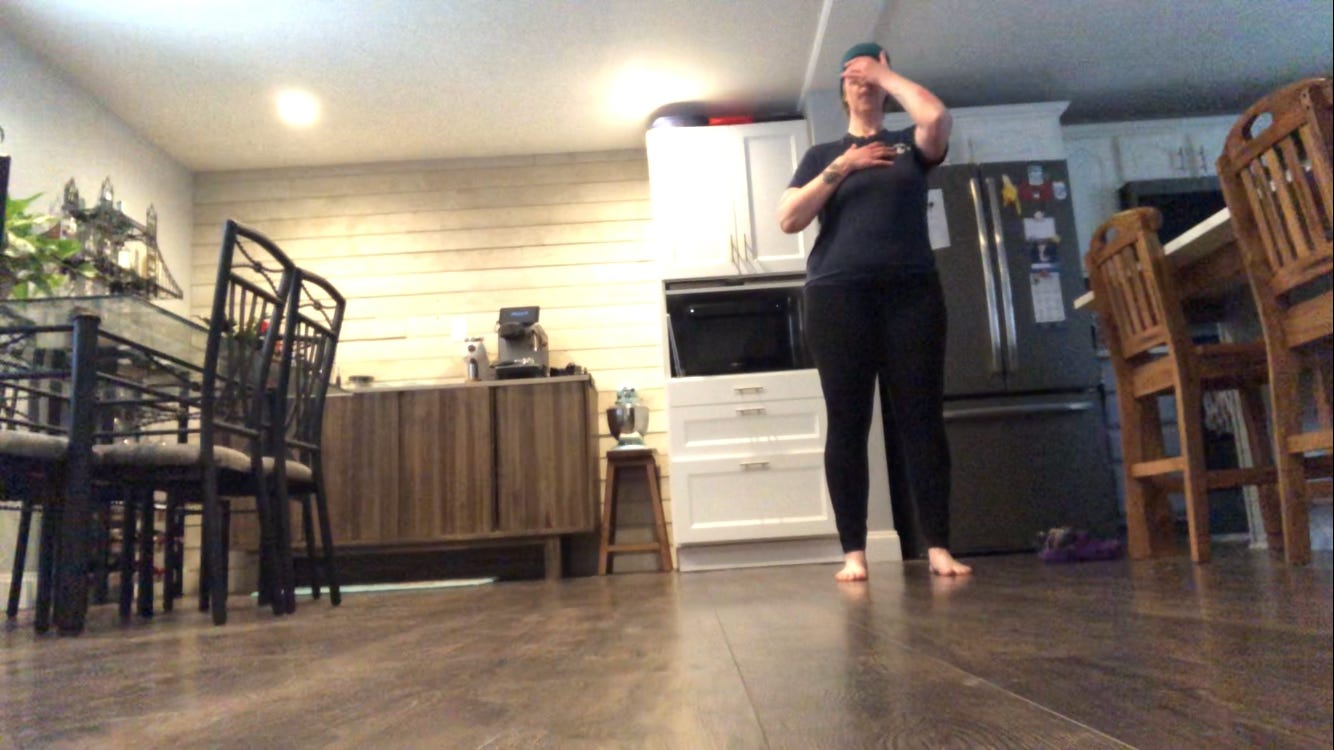 A person dances in a kitchen.