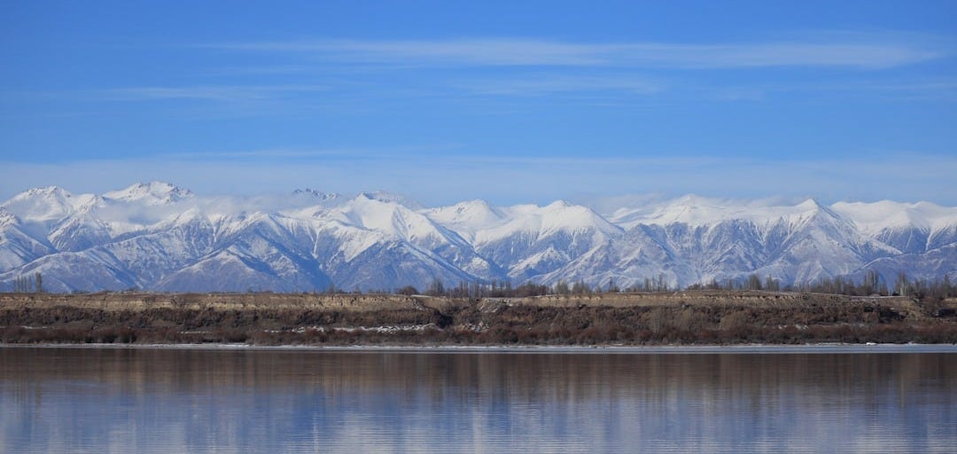 a large body of water with mountains in the background