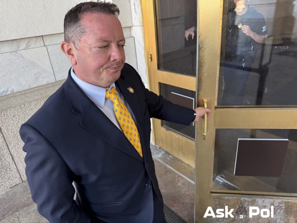Politician in suit and bright yellow tie opens the door to an office building. Photos: Matt Laslo © www.askapol.com Politician in suit and bright yellow tie opens the door to an office building. Photos: Matt Laslo © www.askapol.com