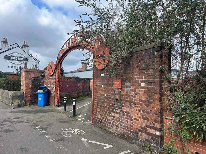 Tow photos. A wall forming an entrance, Chatsworth Road, Chesterfield. A ign on the wall above a hole shows that this was once a railway crossing. A hole in the wall is where a chain was dragged across the raod to stop road traffic crossing. Photos: Roland Millward