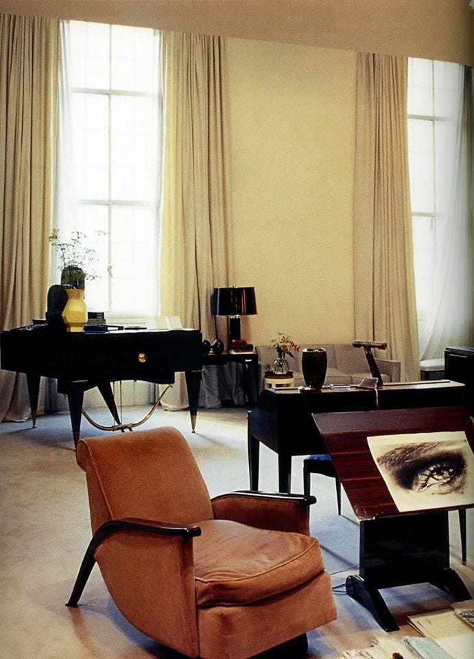 This may contain: a living room filled with lots of furniture and windows covered in draping next to each other