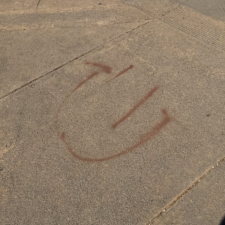 images of smiley faces painted on sidewalks and railings