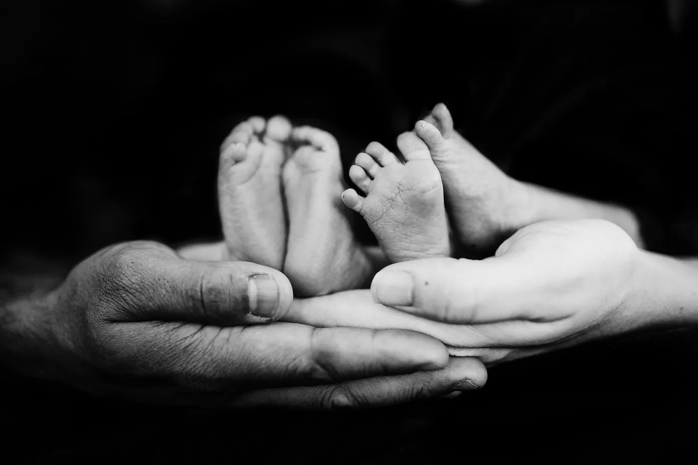 A couple holding their baby's feet for a photograph