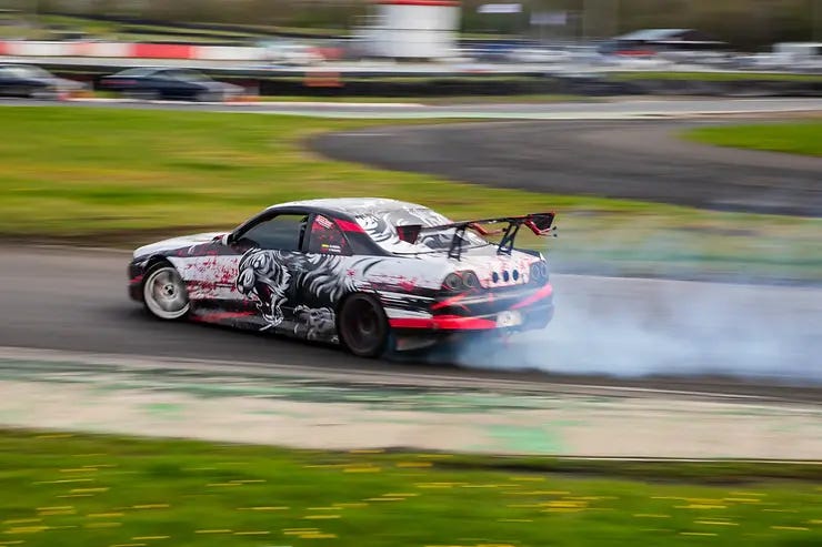 A Car at Three Sisters Circuit, Wigan drifting around the bend with smoke coming from the back tyres. April 2024. A Car at Three Sisters Circuit, Wigan drifting around the bend with smoke coming from the back tyres. April 2024.
