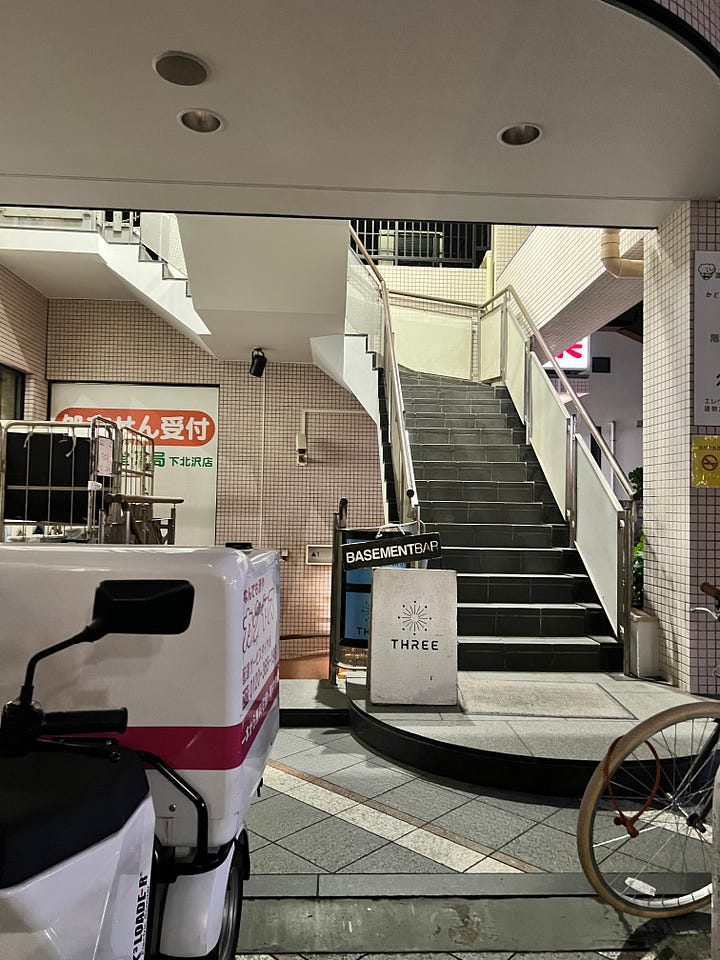 left: staircase to music venue right: punk band playing on stage bathed in a red glow