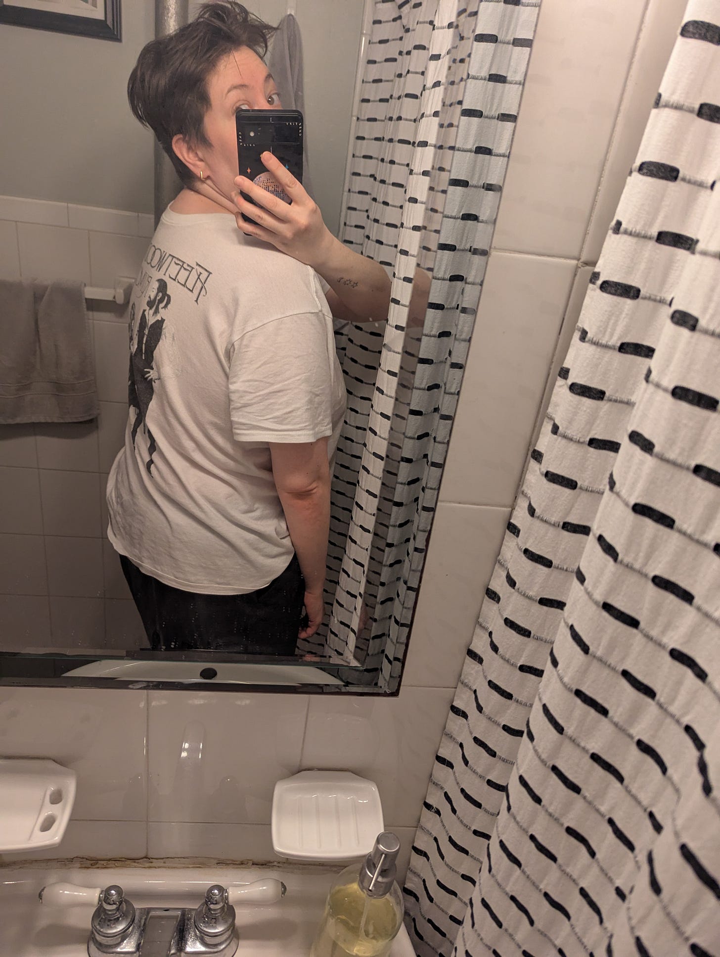 photo of the author taken in the mirror of the bathroom showing her wearing a fleetwood mac t-shirt backwards